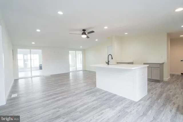 a view of a kitchen with a sink dishwasher a kitchen island with wooden floors