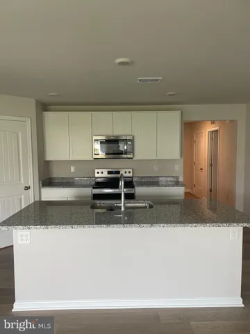 a kitchen with stainless steel appliances a sink stove and cabinets