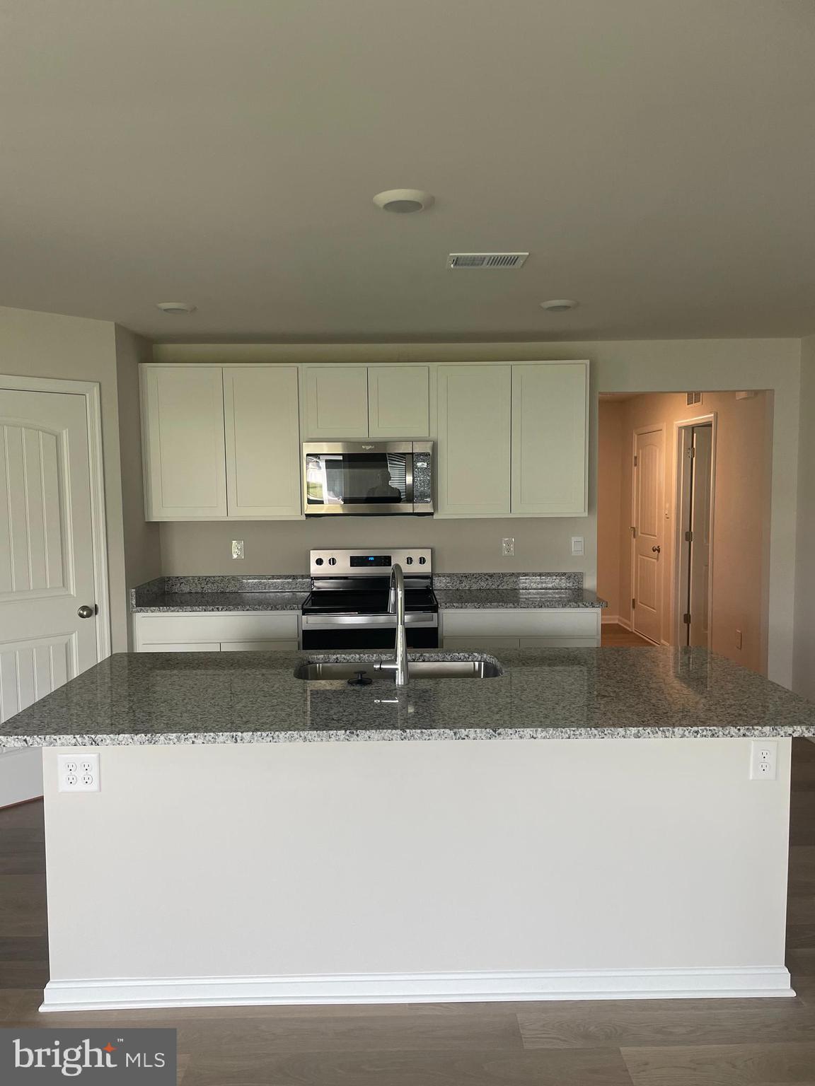 22418 Reeve Road Millsboro, DE 19966 - Photo 4 of 6 a kitchen with stainless steel appliances a sink stove and cabinets