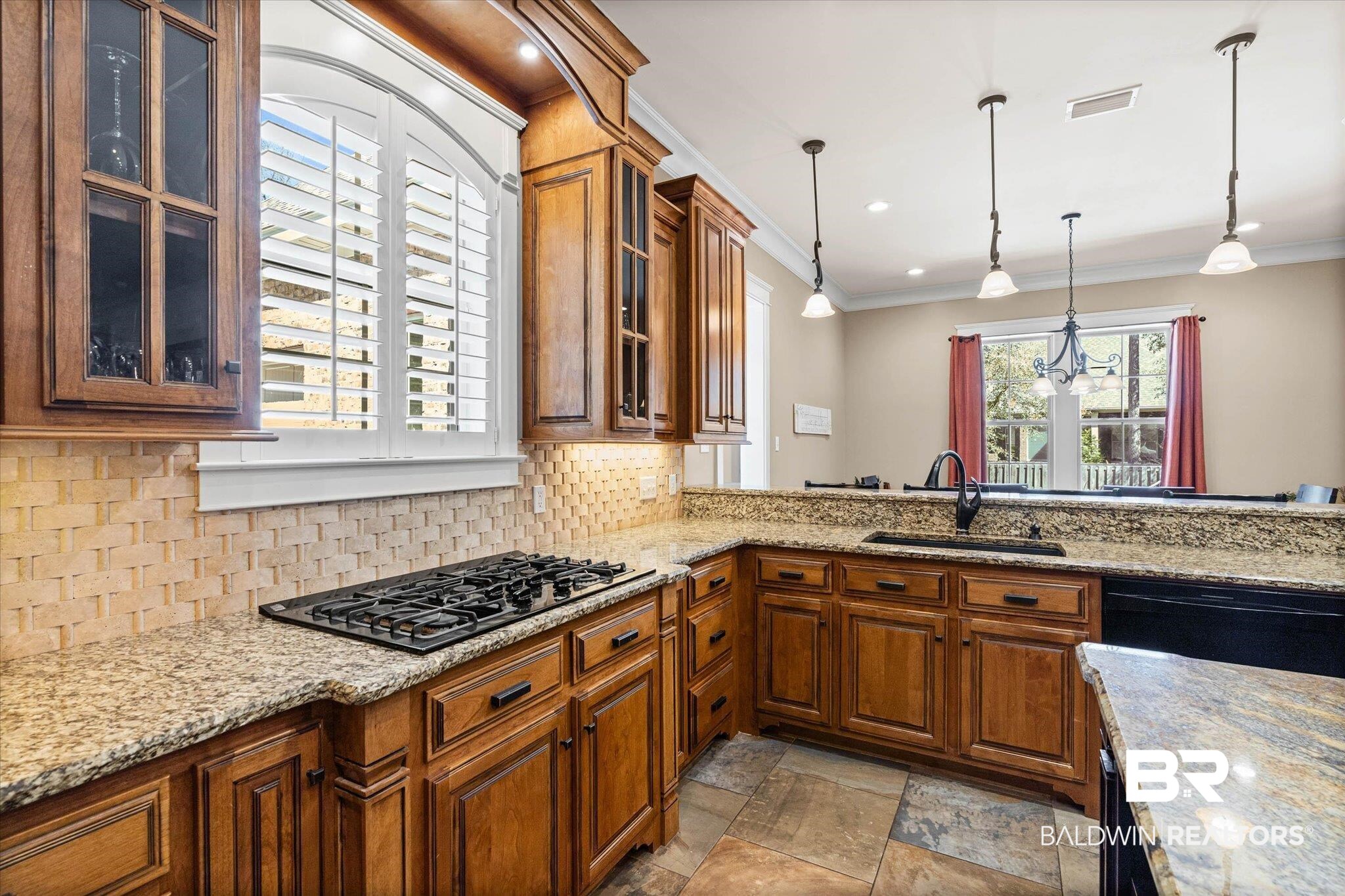 7676 Rockstone Lane Mobile, AL 36695 - Photo 13 of 47 Kitchen featuring wood finish cabinets, glass insert cabinets, light stone counters, and crown molding