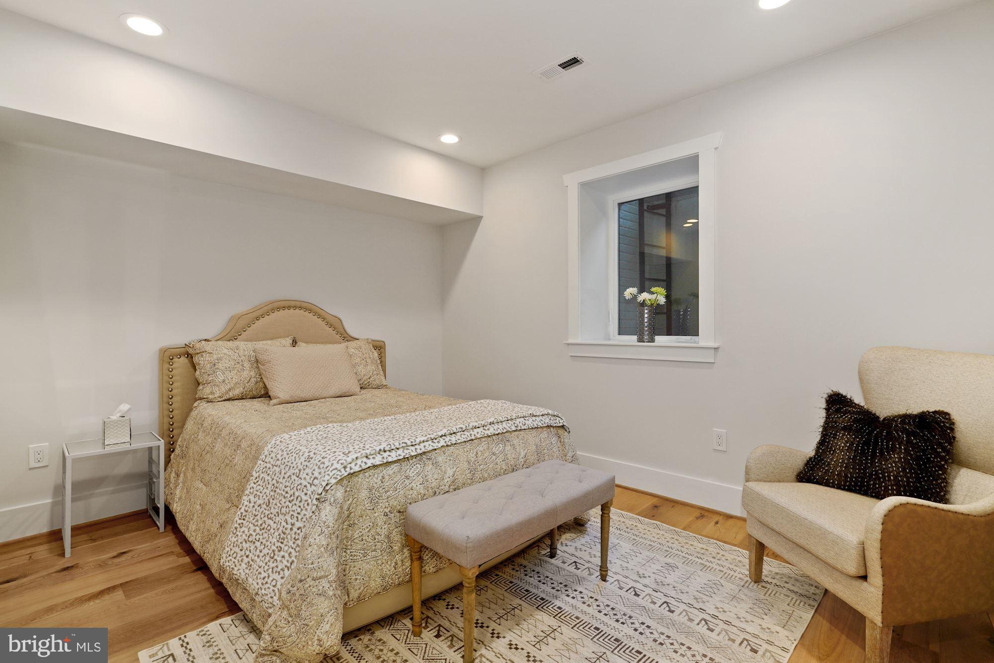 1808 Ontario Place Northwest, Unit 1 Washington, DC 20009 - Photo 13 of 27 a bedroom with a bed and wooden floor