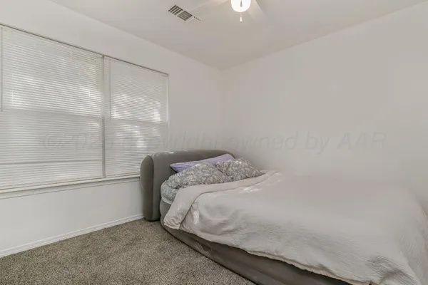 a bed sitting in a bedroom next to a window