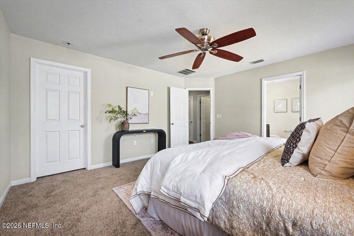 7401 Steventon Way Jacksonville, FL 32244 - Photo 15 of 32 a bedroom with a bed and a chandelier