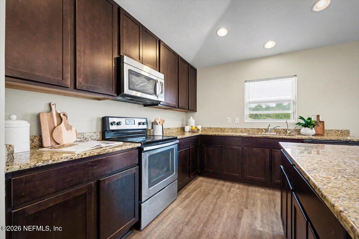7401 Steventon Way Jacksonville, FL 32244 - Photo 18 of 32 a kitchen with granite countertop stainless steel appliances and wooden cabinets