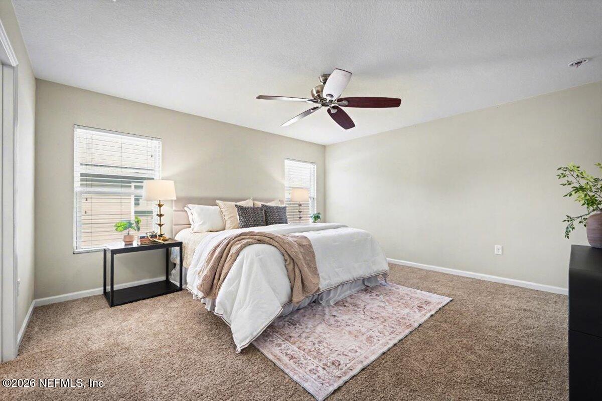 7401 Steventon Way Jacksonville, FL 32244 - Photo 19 of 32 a bedroom with a bed and a chandelier
