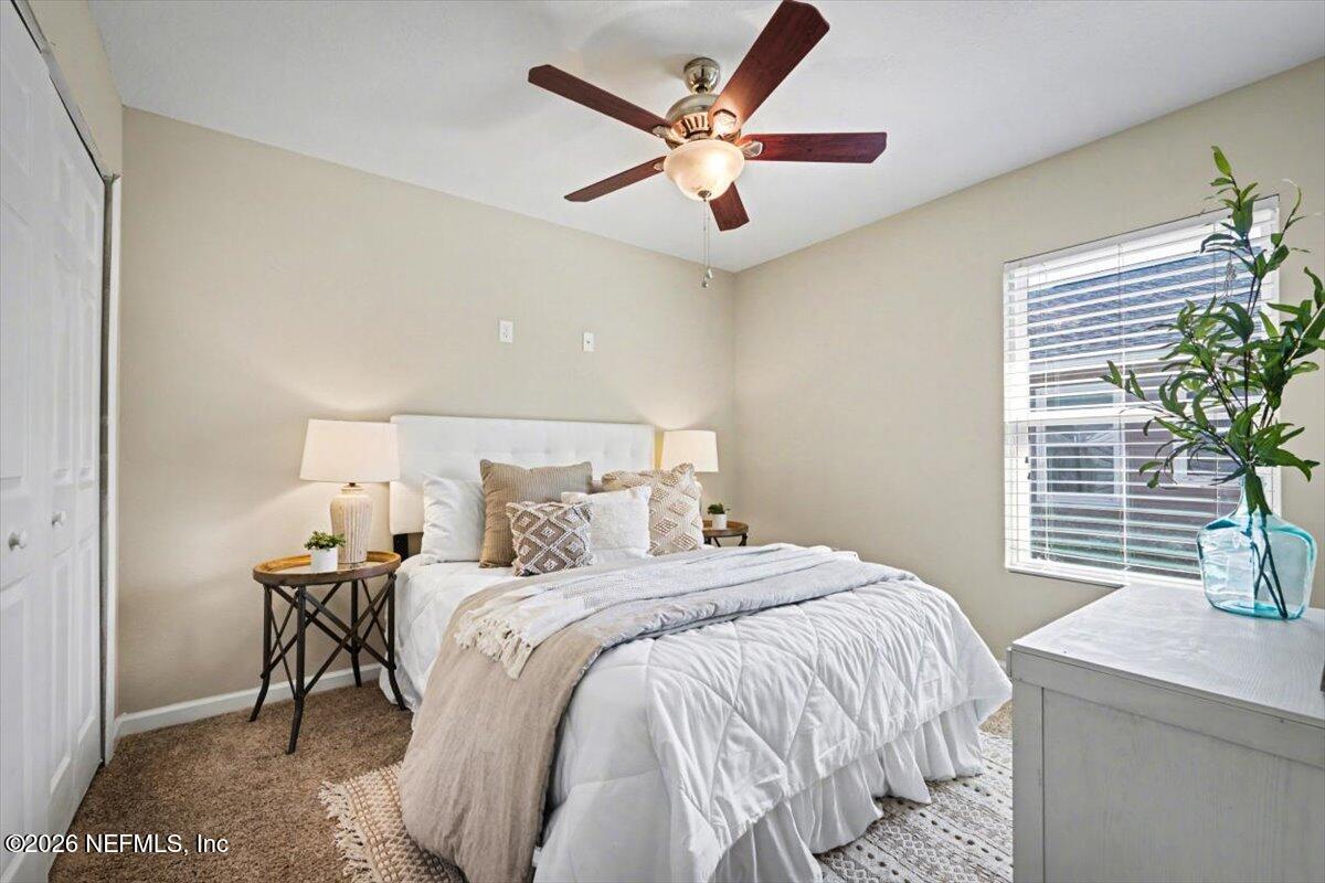 7401 Steventon Way Jacksonville, FL 32244 - Photo 24 of 32 a bedroom with a bed and a chandelier
