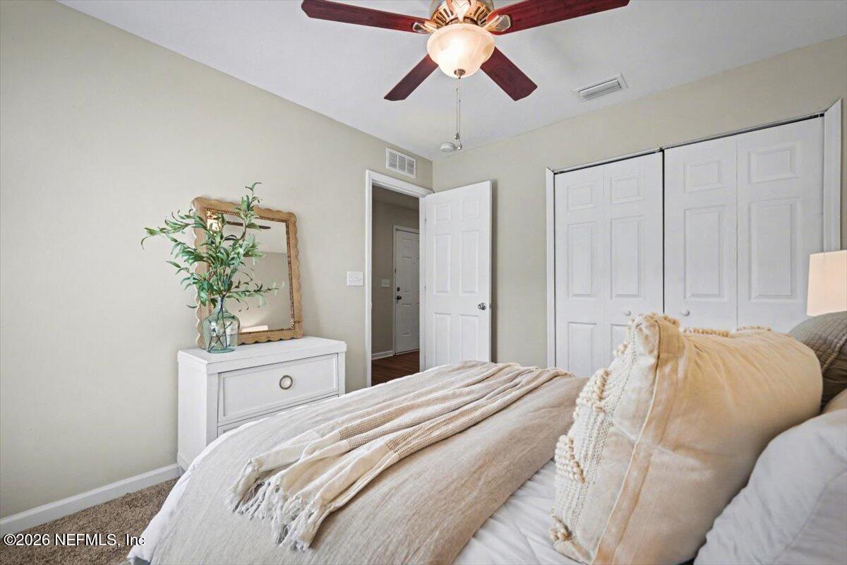 7401 Steventon Way Jacksonville, FL 32244 - Photo 25 of 32 a bedroom with a bed and a chandelier