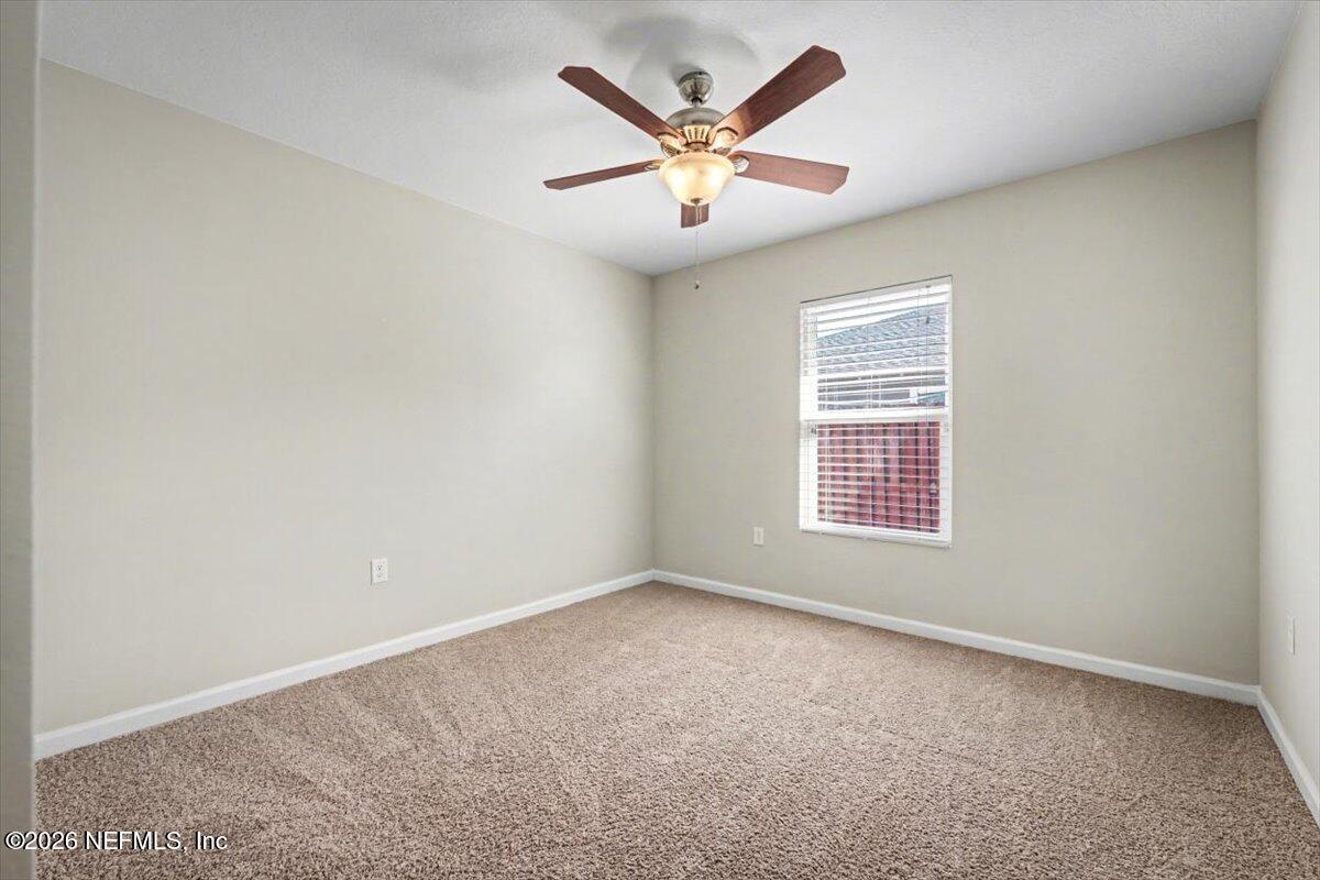 7401 Steventon Way Jacksonville, FL 32244 - Photo 26 of 32 an empty room with a ceiling fan and windows