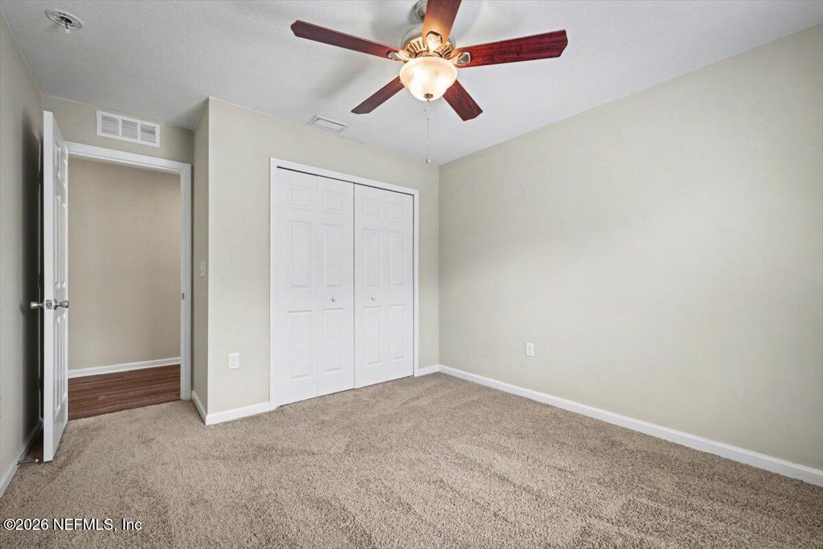 7401 Steventon Way Jacksonville, FL 32244 - Photo 27 of 32 an empty room with closet and a chandelier fan