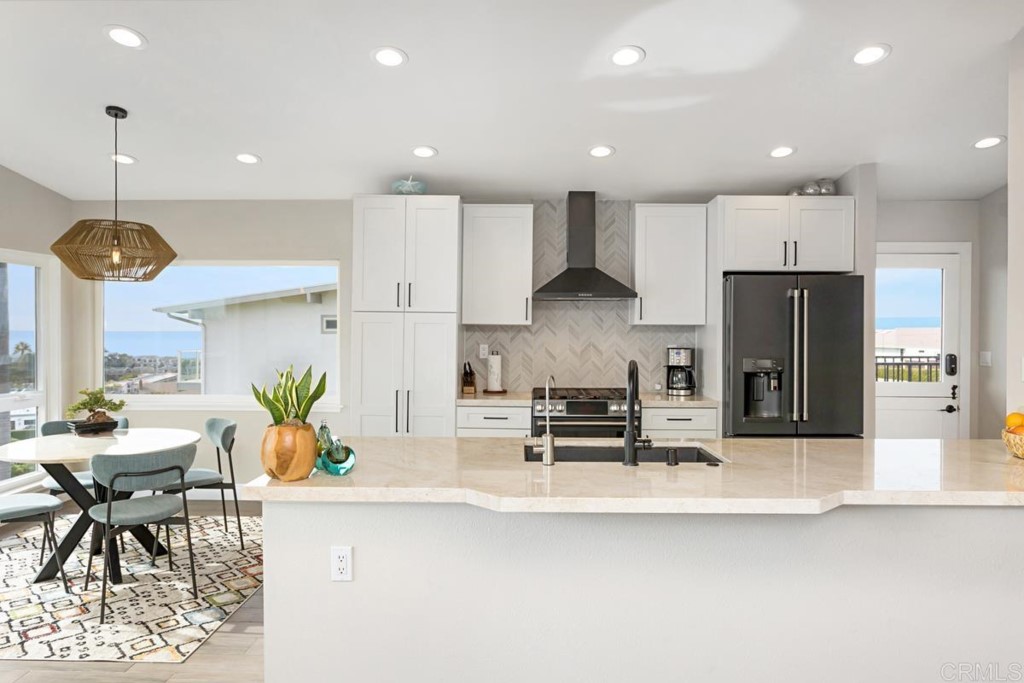 620 West Solana Circle, Unit 3A Solana Beach, CA 92075 - Photo 4 of 37 a kitchen with stainless steel appliances kitchen island granite countertop a refrigerator a stove a sink a dining table and chairs with wooden floor