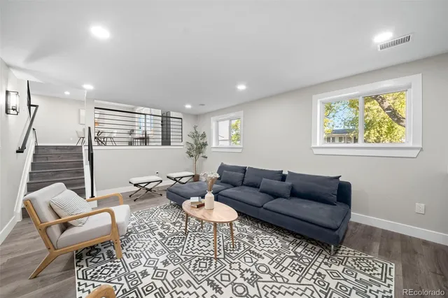 a living room with furniture and a wooden floor