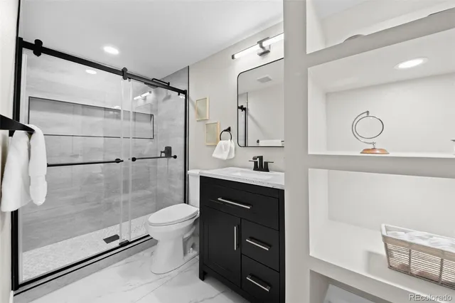 a bathroom with a shower sink mirror and toilet