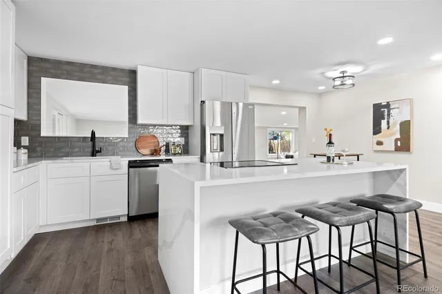 a kitchen with a table chairs refrigerator and cabinets