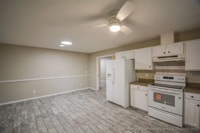 a kitchen with white cabinets and white appliances