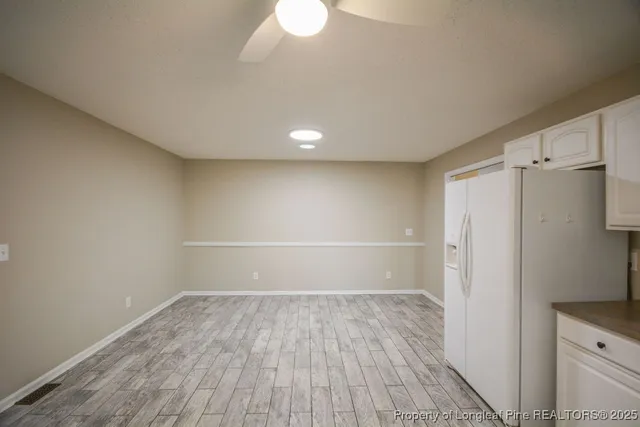 a view of a room with wooden floor and white walls