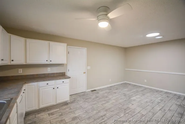 a view of a kitchen with white cabinets and a sink