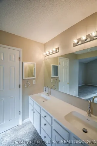 a bathroom with double vanity sink and a mirror