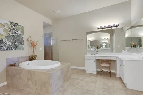 a bathroom with a sink a tub a mirror and a lamp