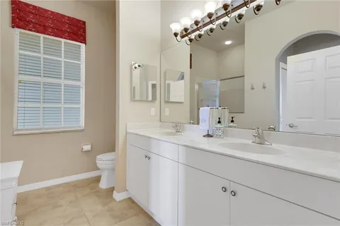 a bathroom with a double vanity sink mirror and toilet
