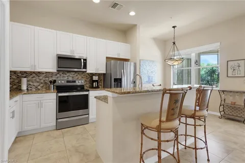 a kitchen with stainless steel appliances a stove a sink refrigerator and a microwave