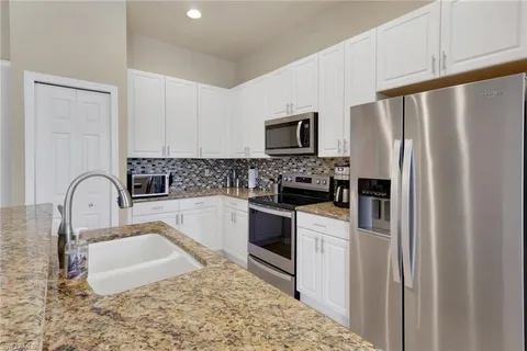a kitchen with stainless steel appliances granite countertop a refrigerator sink and stove