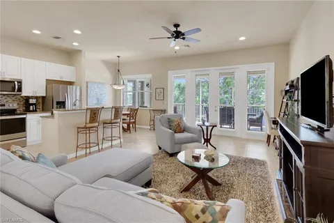 a living room with furniture a flat screen tv and large window
