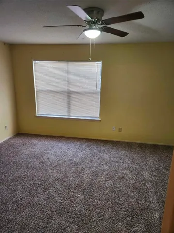 a view of a room with a ceiling fan and a window