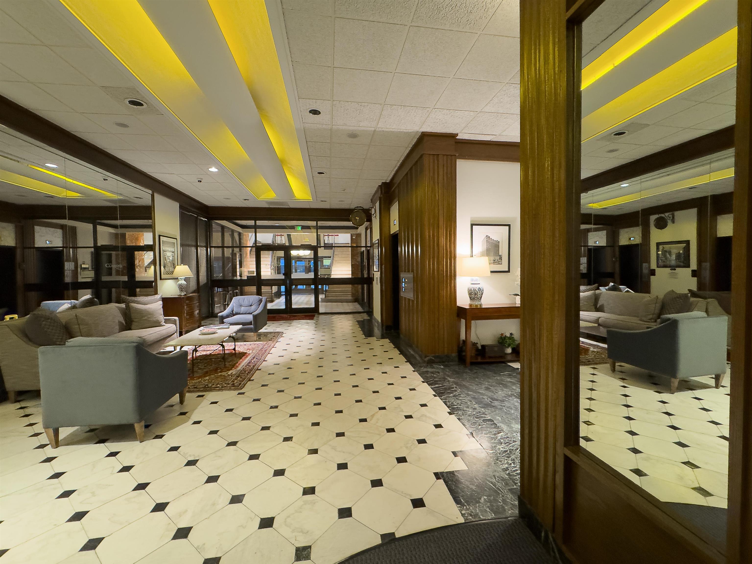 109 North Main Street, Unit 907 Memphis, TN 38103 - Photo 5 of 29 Lobby with patterned tile flooring, wood paneling, and integrated ceiling lighting