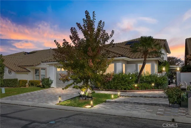 a view of a white house with a fountain and a yard