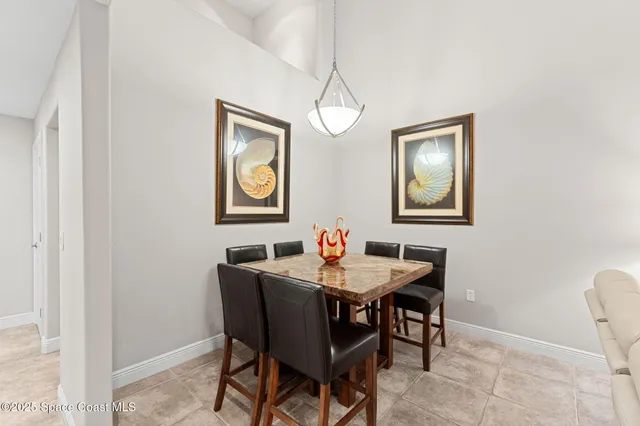 a living room with furniture two large window and a flat screen tv