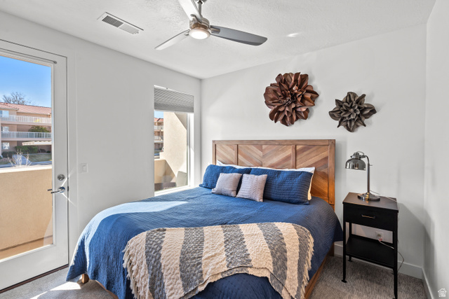 1122 South 1790th Street West, Unit 2 St. George, UT 84770 - Photo 24 of 37 Bright bedroom featuring a chevron wood-finish headboard, a ceiling fan with integrated lighting, and a glass-paneled exterior door opening to a balcony