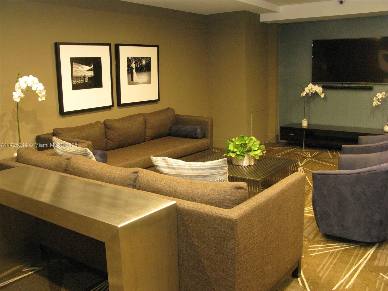 5701 Collins Avenue, Unit 1011 Miami Beach, FL 33140 - Photo 26 of 50 a living room with furniture and a flat screen tv