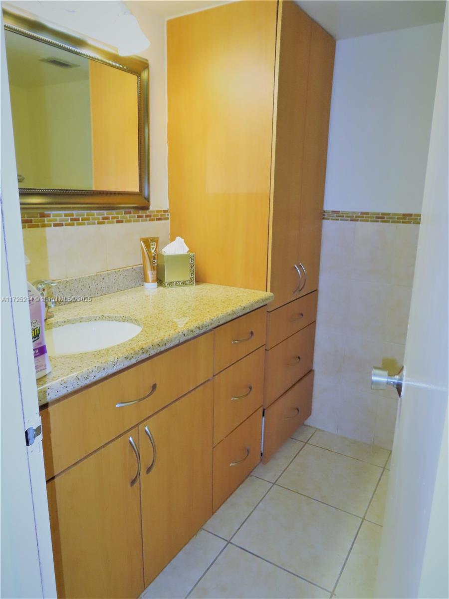 5701 Collins Avenue, Unit 1011 Miami Beach, FL 33140 - Photo 38 of 50 a bathroom with a sink and a mirror