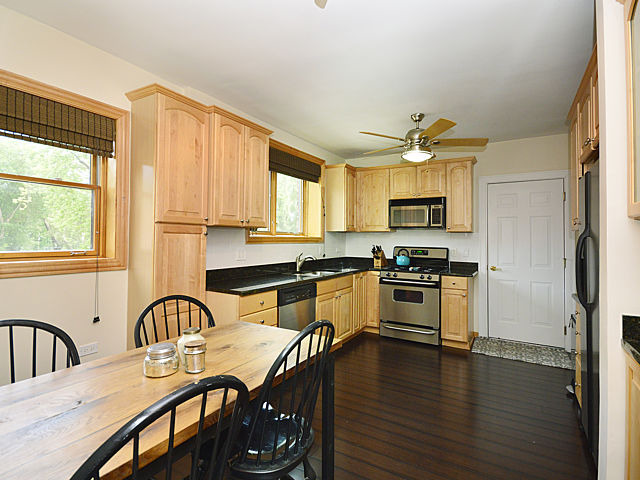 1918 Colfax Street, Unit 3 Evanston, IL 60201 - Photo 4 of 5 a large kitchen with stainless steel appliances a stove a sink a refrigerator dining table and chairs