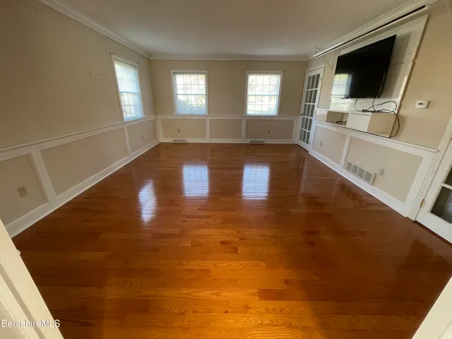 a view of a livingroom with wooden floor and flat screen tv