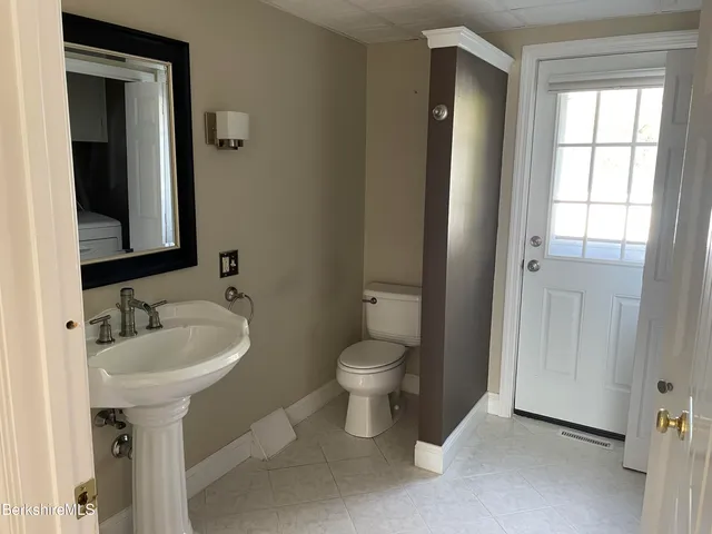 a bathroom with a toilet sink and mirror