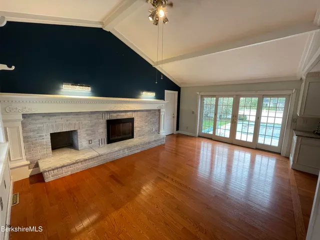 a view of empty room with fireplace and wooden floor