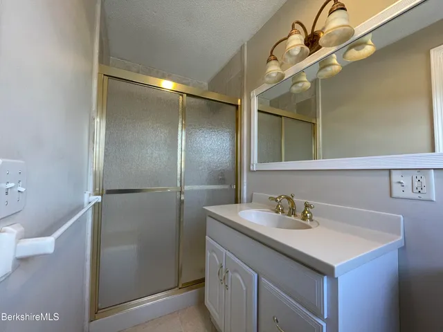 a bathroom with a granite countertop shower and a sink