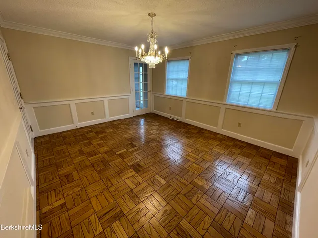 a view of a room with wooden floor and chandelier