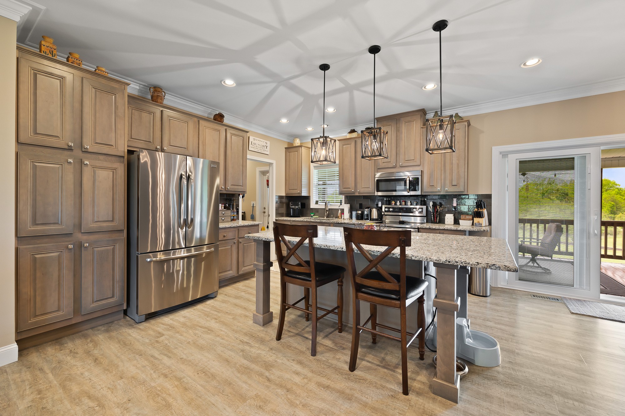 103 Molten Lane Hilham, TN 38568 - Photo 6 of 39 a kitchen with stainless steel appliances granite countertop a refrigerator a oven a sink a dining table and chairs with wooden floor