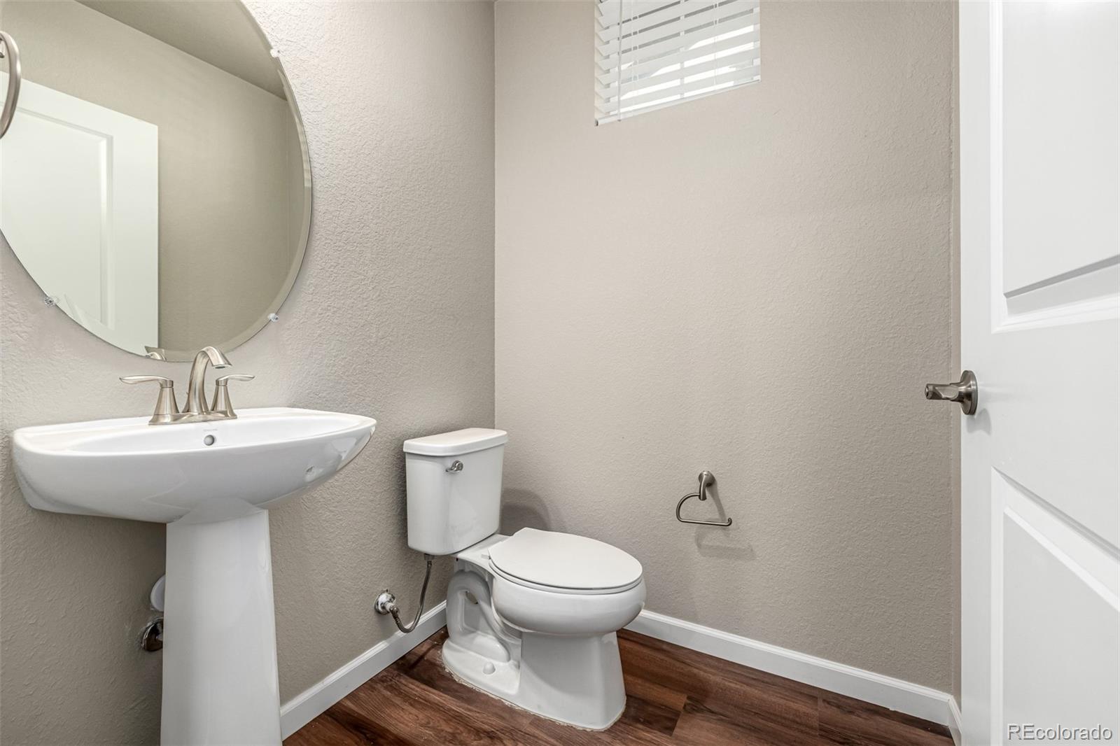 8417 Rizza Street, Unit A Littleton, CO 80129 - Photo 7 of 25 a bathroom with a toilet a sink and mirror