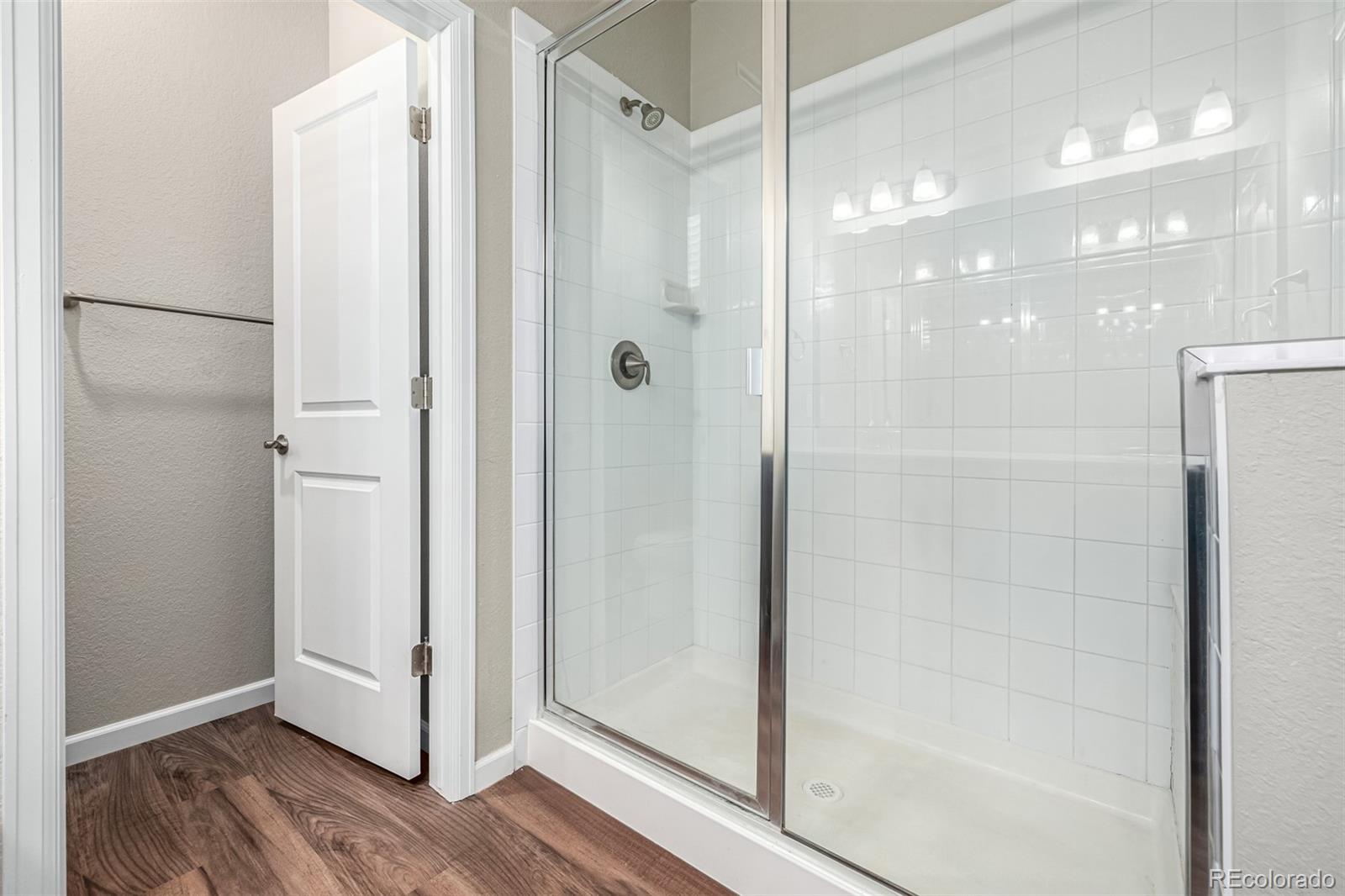 8417 Rizza Street, Unit A Littleton, CO 80129 - Photo 10 of 25 a bathroom with a glass shower door