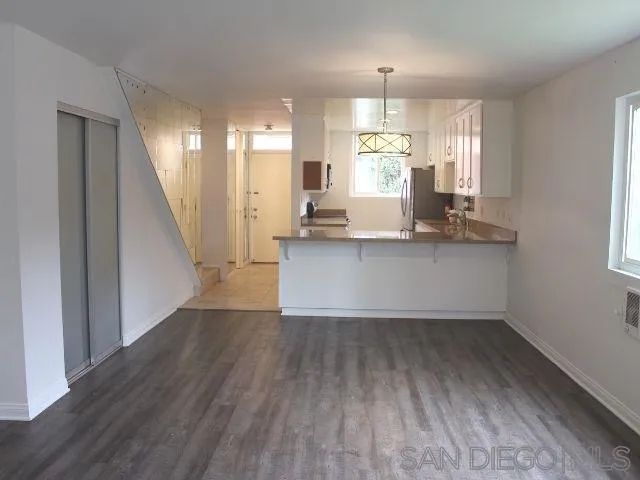 a view of a kitchen with wooden floor and electronic appliances