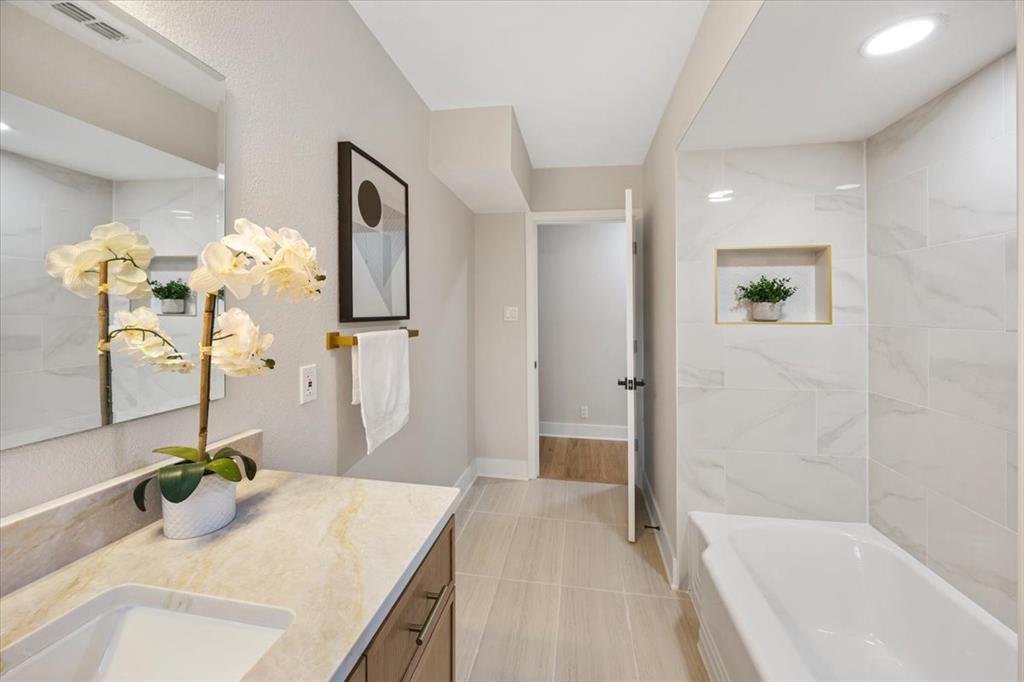 10524 Coleridge Street Dallas, TX 75218 - Photo 14 of 35 a bathroom with a granite countertop sink a mirror and a bathtub