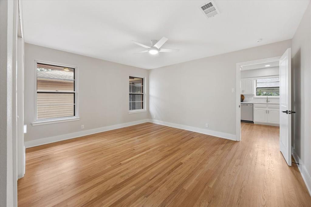 10524 Coleridge Street Dallas, TX 75218 - Photo 20 of 35 an empty room with wooden floor cabinet and windows