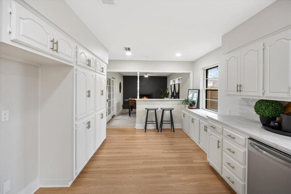 10524 Coleridge Street Dallas, TX 75218 - Photo 23 of 35 a large white kitchen with cabinets and wooden floor