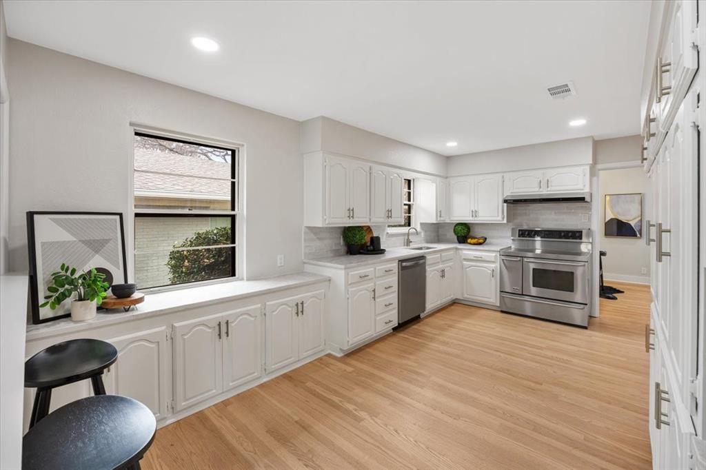 10524 Coleridge Street Dallas, TX 75218 - Photo 25 of 35 a kitchen with white cabinets and white appliances