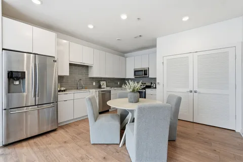 a kitchen with white cabinets and stainless steel appliances