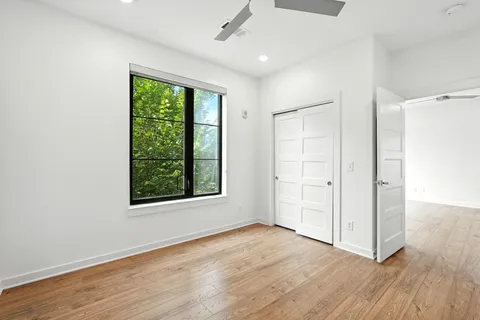 an empty room with wooden floor and windows