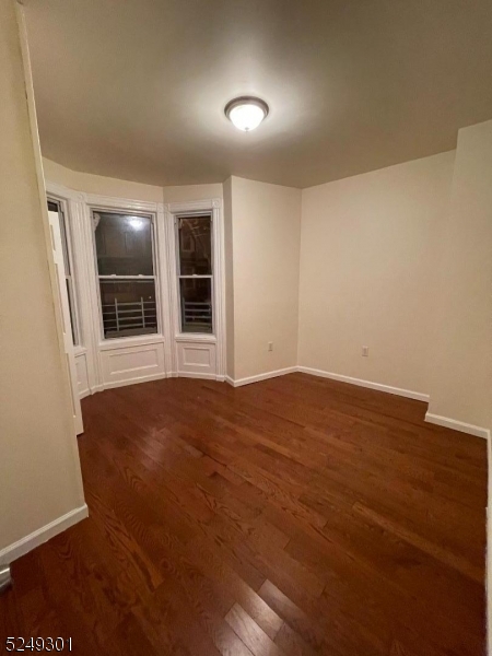 89 Cutler Street, Unit 1 Newark, NJ 07104 - Photo 1 of 7 an empty room with wooden floor and windows